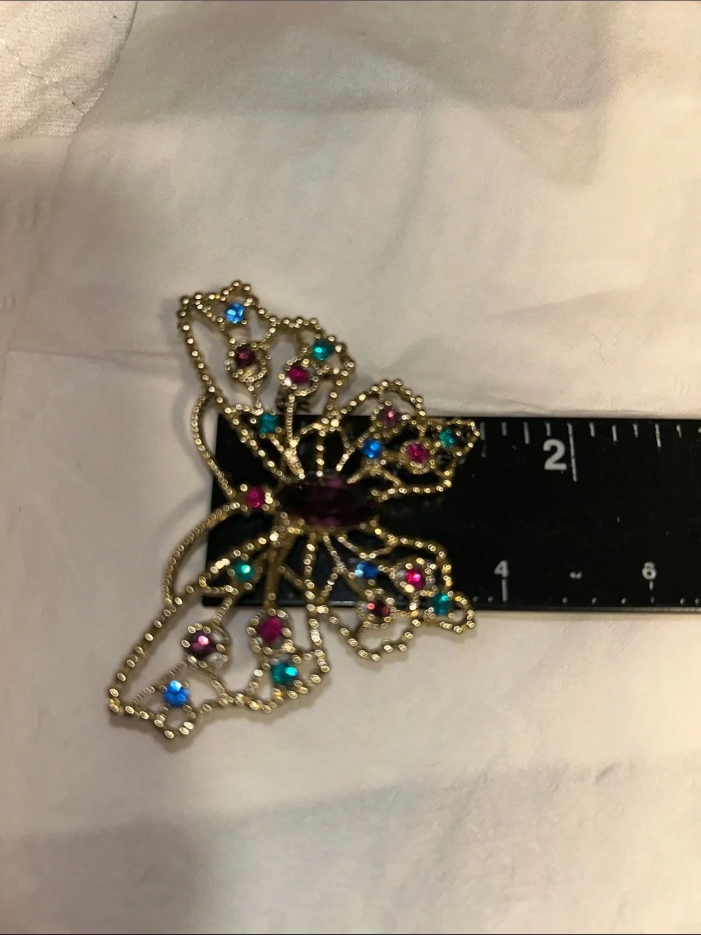 Dodds filigree butterfly brooch featuring a large amethyst-colored center stone